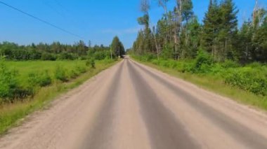 Motokros yarışçısı plaka kullanıyor, engebeli off-road 'a biniyor, dağlarda hızlı sürüş yapıyor, aşırı maceralar yaşıyor. Arka plan Sürücü Plakası Kırsal yolda geriye doğru bakıyor.