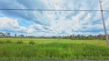 Burk 's Falls Ontario, Pickerel Gölü manzaralı destansı yolda, bulutlu mavi gökyüzü ve kırsal kesimde yeşil köknar ağaçları olan bir araç. Geniş açı görünümü.