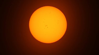 Güneş lekeli, güneşli, güzel bir gün batımı. Güneş filtresiyle yapılmış büyük, sıcak güneş aşırı yakın çekim. Astronomi hobisi. Sıcak yaz atmosferi sıcak hava dalgasında. 