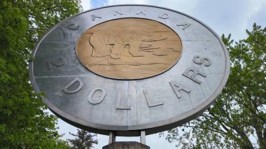 Eski Değirmen Parkı 'nda iki dolarlık Kanada sikkesinin dev Toonie kopyası. Şehir merkezi, kuzey doğu Ontario. Kanada Darphanesi. Turistler için Cazibe: Campbellford, Ontario, Kanada - 15 Mayıs 2024