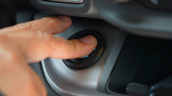 Starting car engine. Finger pushing start stop engine button. Finger press the button to start the car engine, modern transport and technology.