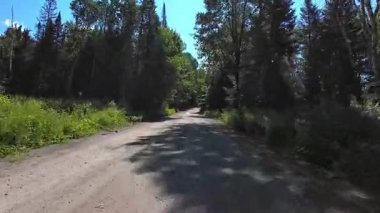 Sürücü plakası, doğal güzellik ve macera sergiliyor. Çakıl yolu ve vahşi doğa boyunca birinci şahıs manzarası Ontario Kanada 'nın kraliyet arazisinin yakınından geçiyor. Dağlık yolda yolculuk.