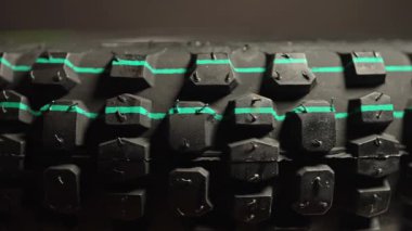 Motosiklet lastiği yeni görünüyor. Yeni dağ bisikleti lastiğinin makro yakın çekim görüntüsü. Motosiklet sporlarında hız yarışında tutuş için agresif lastik izleri. Motokros lastiği dönüyor. Ekstrem sporlar.