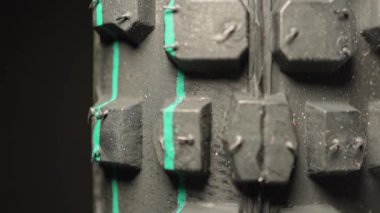 Motosiklet lastiği yeni görünüyor. Yeni dağ bisikleti lastiğinin makro yakın çekim görüntüsü. Motosiklet sporlarında hız yarışında tutuş için agresif lastik izleri. Motokros lastiği dönüyor. Ekstrem sporlar.
