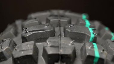 Dönen motorsiklet tekerleği lastiği. Siyah, yeni, kauçuk bisiklet lastiği rotasyonu. Otomobil servisi konsepti, tekerlek değiştirme. Dönen tekerlek denetimi. Ekstrem sporlar ve motokros lastikleri. Ağır çekimde kapat.
