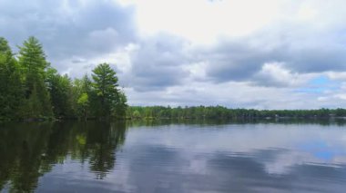 Suyun içinden geçen bir gemiden Pov. Kanada Gölü 'nde tekne manzarası, küçük teknenin pruvasında. Küçük taç köknar ağacı adaları kıyısı. Güneşli bir günde bulutlu bir havada motorlu tekne. Seyahat ve macera.