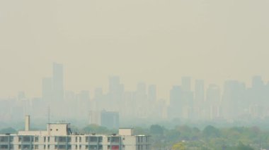 Smoke from Canadian and United States burning wildfires creates hazy air and heat dome. Fire and heavy smoke plume causes environmental disaster, intense smoke and poor air quality and visibility.