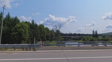 Kenarlarında yeşillik olan 11. Otoyol 'un yan manzarası. Arabayla manzara gezisi, sürücü bakış açısı POV. Asfalt yol boyunca sürüş plakası gezisi: Burk 's Falls, Ontario, Kanada - 15 Temmuz 2024