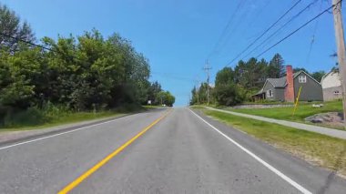 Pickerel Gölü 'nün Ontario kentindeki Burk' s Falls kasabasında, kırsal kesimde evleri olan asfalt karayolunun geniş açılı görüntüsü: Burk 's Falls, Ontario, Kanada - 15 Temmuz 2024