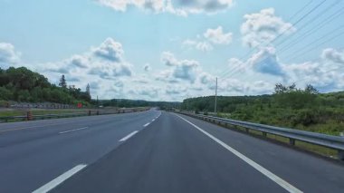 Kenarlarında yeşillik olan 11. karayolu manzarası. Arabayla manzara gezisi, sürücü bakış açısı POV. Burk 's Falls, Ontario, Kanada - 15 Temmuz 2024