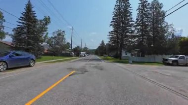 Pickerel Gölü 'nün Ontario kentindeki Burk' s Falls kasabasında, kırsal kesimde evleri olan asfalt karayolunun geniş açılı görüntüsü: Burk 's Falls, Ontario, Kanada - 15 Temmuz 2024