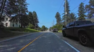 Pickerel Gölü 'nün Ontario kentindeki Burk' s Falls kasabasında, kırsal kesimde evleri olan asfalt karayolunun geniş açılı görüntüsü: Burk 's Falls, Ontario, Kanada - 15 Temmuz 2024
