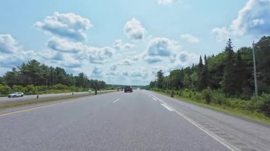 Kenarlarında yeşillik olan 11. karayolu manzarası. Arabayla manzara gezisi, sürücü bakış açısı POV. Burk 's Falls, Ontario, Kanada - 15 Temmuz 2024