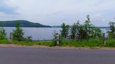 Kanada 'nın kırsal kesimindeki göl manzaralı yan sürücü arabası. Yaz tatili boyunca seyahat ve macera. LED ses, yeşil ekran ve yan projeksiyon için plaka.