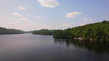 Kuzey Ontario 'daki Baptist Gölü' nün havadan görünüşü. Yaz günü Kanada Gölü 'nün kuş bakışı manzarası. Kır evinin kalbinde çarpıcı yeşil yemyeşil ormanların çerçevelediği güzel bir tatlı su gölü manzarası..