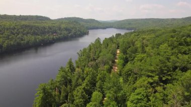 Kuzey Ontario 'daki Baptist Gölü' nün havadan görünüşü. Yaz günü Kanada Gölü 'nün kuş bakışı manzarası. Kır evinin kalbinde çarpıcı yeşil yemyeşil ormanların çerçevelediği güzel bir tatlı su gölü manzarası..