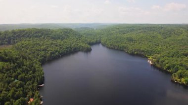 Kuzey Ontario 'daki Baptist Gölü' nün havadan görünüşü. Yaz günü Kanada Gölü 'nün kuş bakışı manzarası. Kır evinin kalbinde çarpıcı yeşil yemyeşil ormanların çerçevelediği güzel bir tatlı su gölü manzarası..