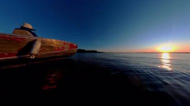 Huron Gölü 'ndeki Manitoulin adasında göl üzerinde gün batımı. Balıkçı turistlerle balıkçı teknesi işletmenin güzel manzarası. Seyahat anlarının sakin sahnesi ve balık oyunu sırasındaki macera.