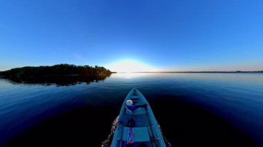 Akşam Huron Gölü 'ndeki Manitoulin Adası' nda gün batımında tekne gezisi. Yaz güneşinin battığı iç gölde bir tekne ve insanların silueti görülüyor. Akşamları balıkçı teknesine binmek..