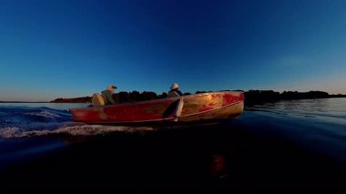 Huron Gölü 'ndeki Manitoulin adasında göl üzerinde gün batımı. Balıkçı turistlerle balıkçı teknesi işletmenin güzel manzarası. Seyahat anlarının sakin sahnesi ve balık oyunu sırasındaki macera.