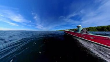 Huron Gölü 'ndeki Manitoulin Adası' nda akşam teknesi. Yaz günbatımında iç gölde bir tekne ve kadın manzarası. Akşamki balık oyunundan sonra balıkçı teknesine binmek..