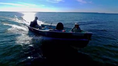 Manitoulin Adası gölünde altın saat balığında levrek avı. Taze Kanada sularında balık tutmak. Göldeki balıkçı teknesinin hızlı süzülüşü. Huzurlu bir tatil..