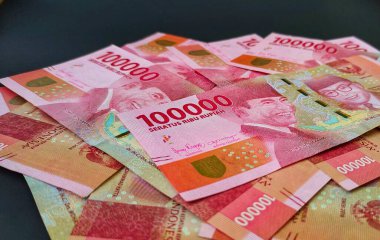Siyah arka planda izole edilmiş 100.000 rupilik Endonezya banknotları..