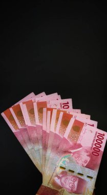 Endonezya 'nın siyah arka planda izole edilmiş 100.000 rupia banknotları.