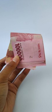 Birkaç Endonezya 100 bin rupia banknotu beyaz arka planda izole edilmiş..
