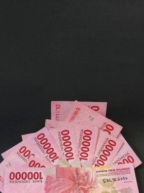 Endonezya rupia 'sının aranjmanı siyah arka planda izole edilmiş 100.000 banknot.