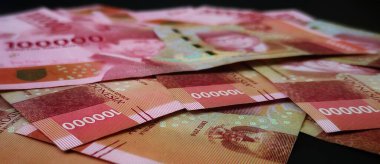 Seçici Endonezya 'ya odaklan. Siyah arka planda izole edilmiş 100.000 rupi..