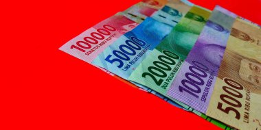 Endonezya 5000, 10000, 20.000, 50000 ve 100000 rupiah banknot kırmızı arka planda izole edilmiştir..