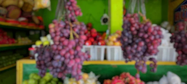 Blur portrait of fruits in fruit shop, such as grapes, mangoes, apples, oranges. Suitable for background