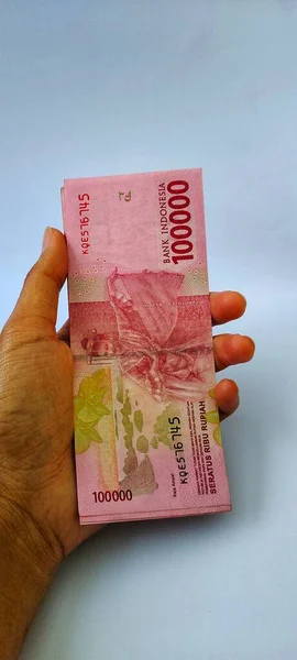 Birkaç Endonezya 100 bin rupia banknotu beyaz arka planda izole edilmiş..