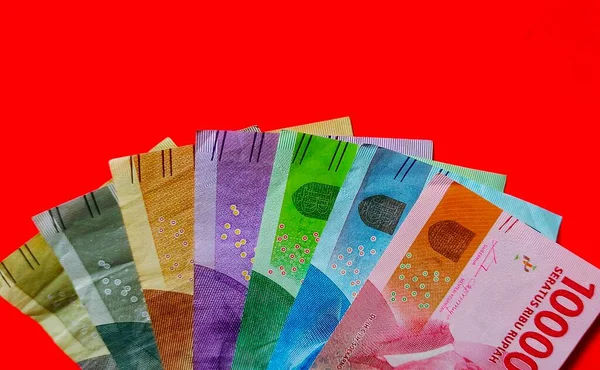 Endonezya 1000, 2000, 5000, 10000, 20000, 50000 ve 100000 rupiah banknot kırmızı arka planda izole edilmiştir..