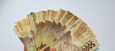 Several sheets of 5000 Indonesian rupiah banknotes isolated on white background. Money concept background