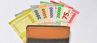Bir cüzdanın üst görüntüsü ve 2022 'de basılan Endonezya banknotları. Rupiah para birimi kavramı beyaz arka planda izole.