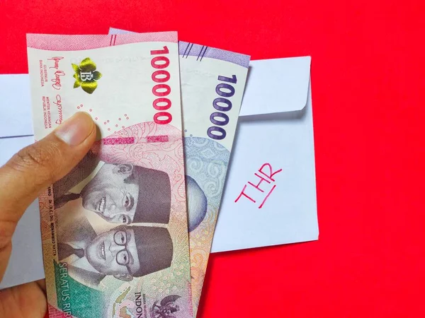 THR ve genellikle Tunjangan Hari Raya veya THR olarak adlandırılan yeni Endonezya banknotlarından oluşan beyaz bir zarf bayram öncesinde çalışanlara veriliyor. Üst görünüm