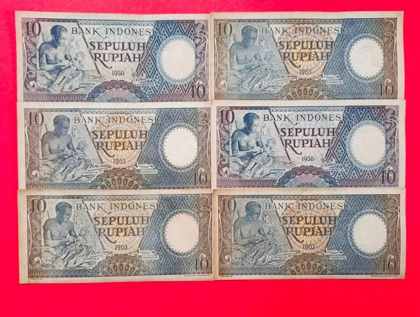 Eski Endonezya banknotlarının portresi Rp.10.00 rupiah 1963 'te basıldı. Kırmızı arkaplanda izole edilmiş eski rupiah para birimi kavramı, üst görünüm