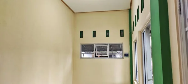 Üzerinde krem rengi duvarlar, pencereler ve havalandırma olan boş bir oda..