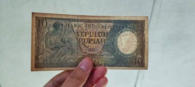 İnsan eli Endonezya banknotunu tutuyor