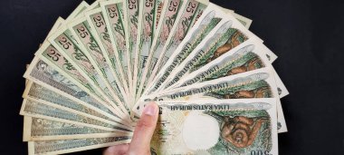 Eski Endonezya banknotlarını tutan adam. Siyah arka planda izole edilmiş eski rupiah para birimi kavramı. Yüksek açı görünümü