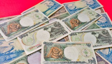 Eski rupiah para geçmişinin portresi. Eski rupiah kavramı, yüksek açı görünümü kırmızı arkaplanda izole edilmiş.