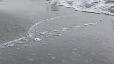 Kumlu sahilde deniz dalgaları  