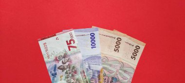 Kırmızı arkaplanda izole edilmiş yeni rupiah banknotlarının üst görünümü