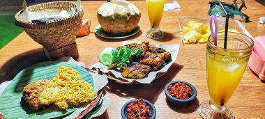 Pilavlı ızgara tavuk, acılı karides sosu, salatalık dilimleri ve fesleğen yaprağı. Orijinal Endonezya ızgara tavuk tarifi.