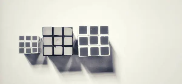 MAGELANG, INDONEZYA - 25 Nisan 2024: Nesneye gölge etkisi vererek üç Rubik 'in fotoğrafının siyah beyaz fotoğrafı.