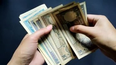 Adamın biri Rp 'den bir avuç dolusu eski rupiah parası gösteriyor. 10 'dan Rp' ye. 500 rupi. Görüntüyü kapat ve siyah arkaplanda izole et.