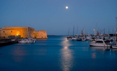 Koule Kalesi ile birlikte eski Venedik Heraklion Limanı 'nın gece fotoğrafı. Yat limanı ve yelkenli manzarası