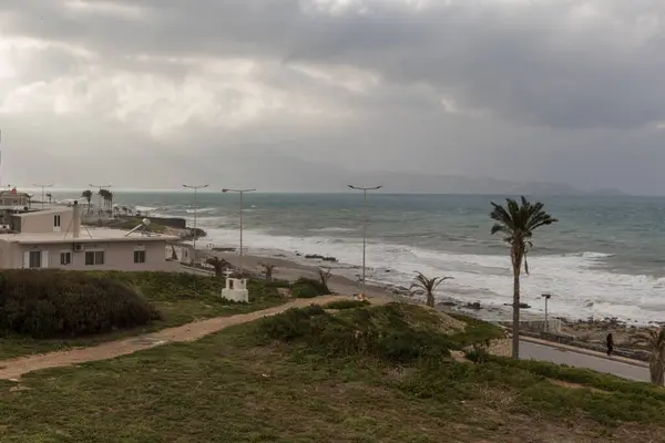 Heraklion plaj sokağında bir kış günü. Bulutlu bir gün, arka planda dalgalı bir deniz var. Eski Venedik duvarlarına bak.